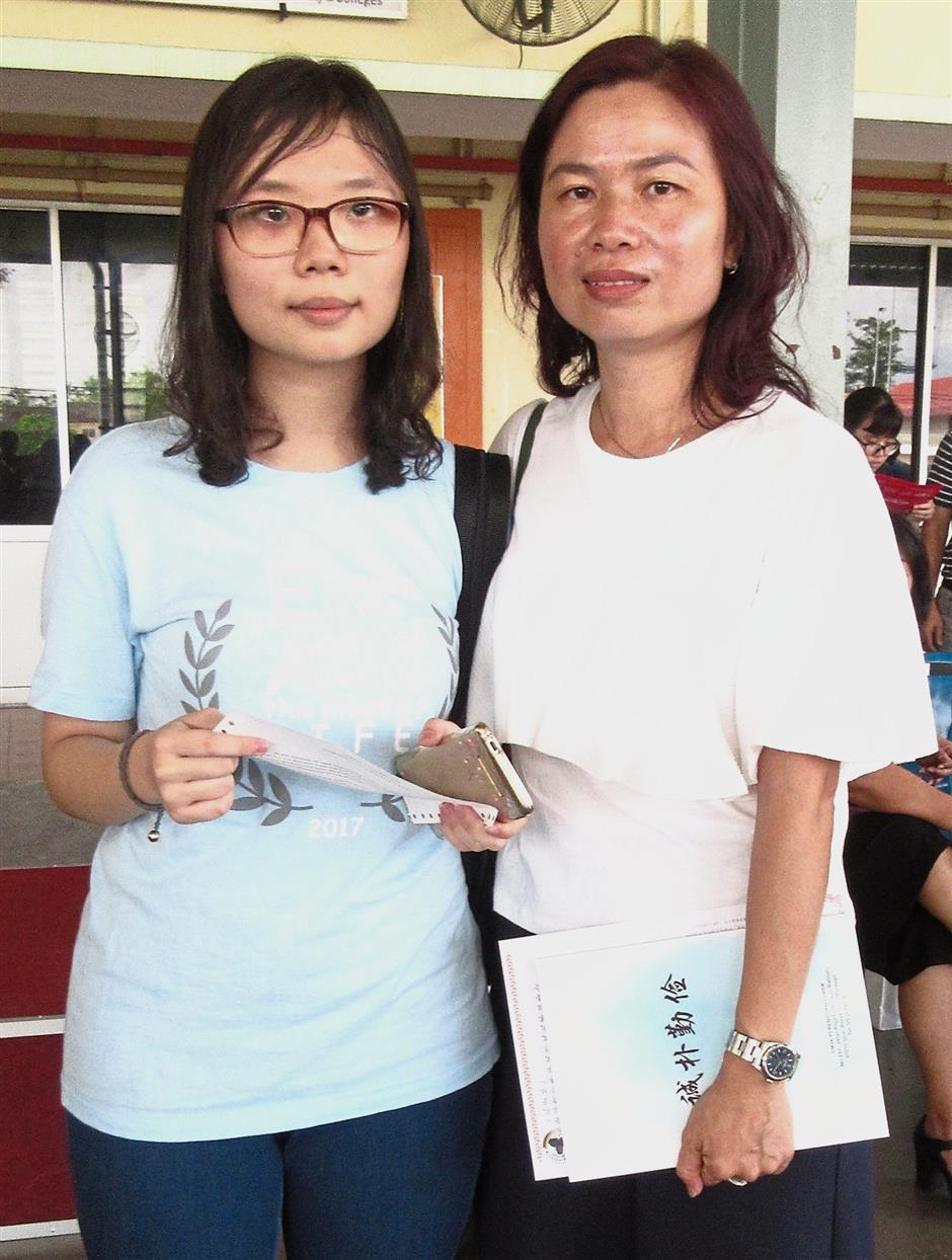 Weng Sam (left) took her vision impairment in her stride in scoring 4As and 2Bs in her SPM. With her is her mother Ho.