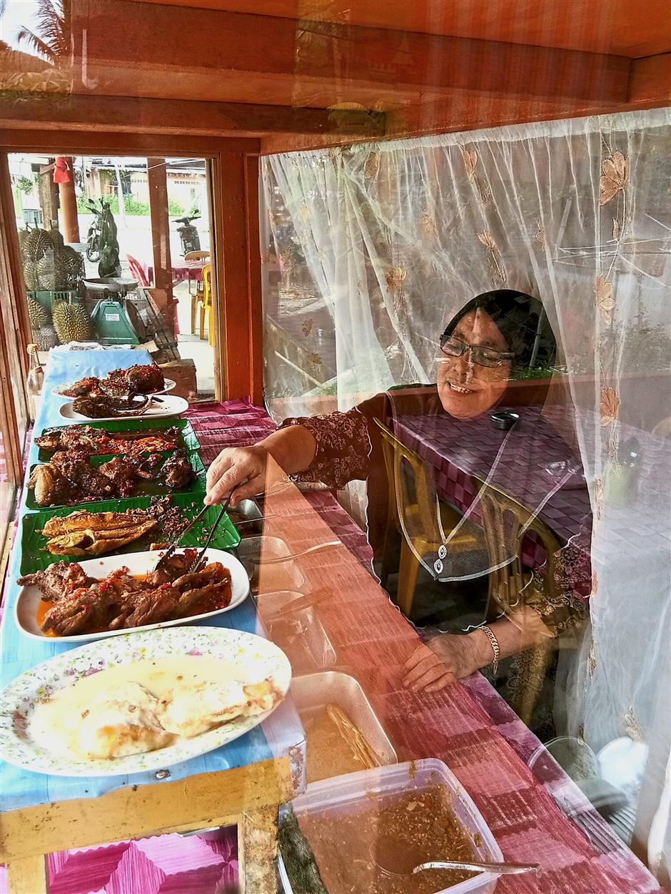 Siti Aishah cooks catfish caught from the Semenyih Dam to make her specialty spicy tamarind catfish dish.