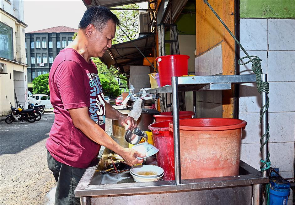 Cheong using minimal amount of water to wash utensils at his eatery.