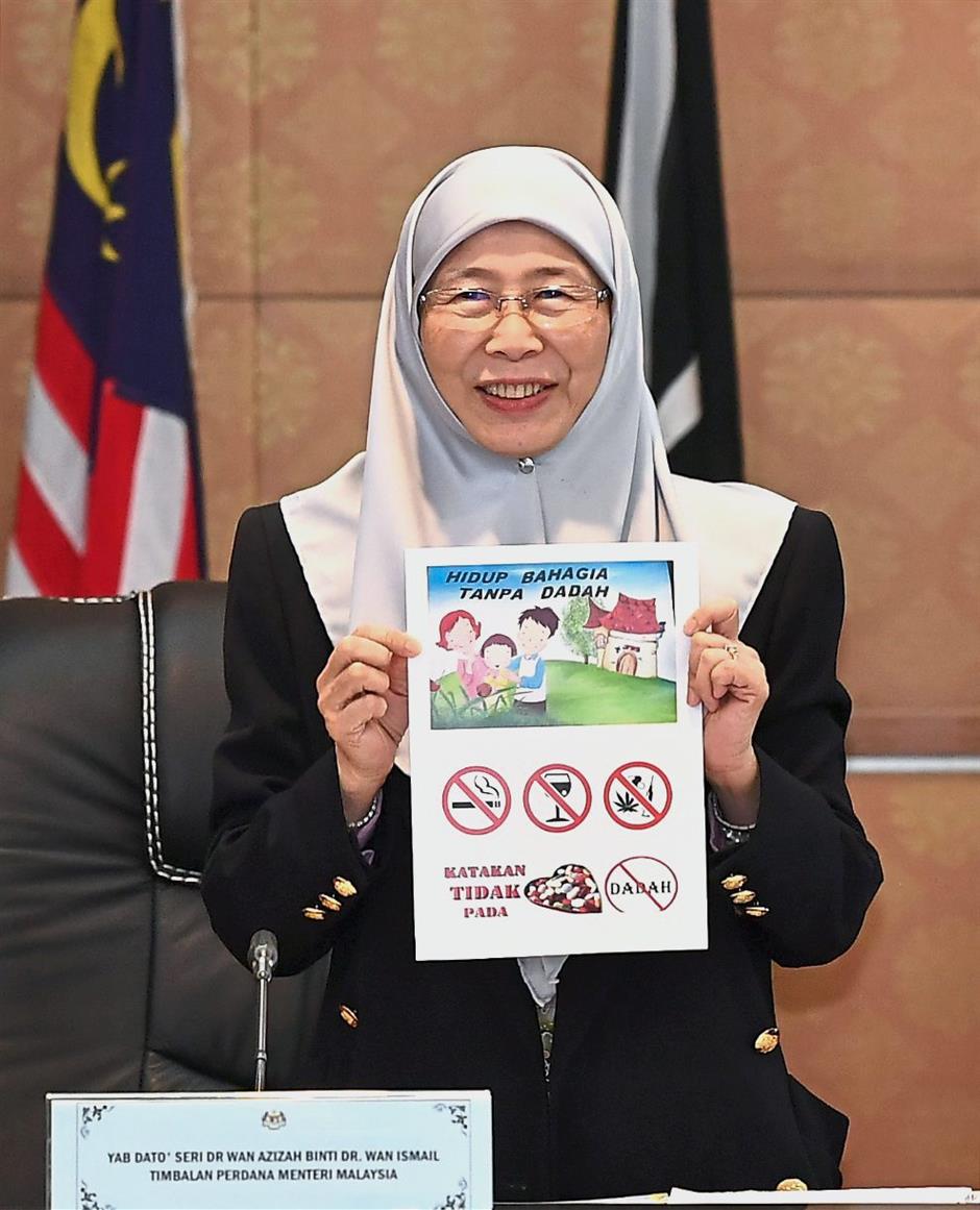 A healthy message: Dr Wan Azizah showing the anti-drugs campaign pamphlet to the media after the meeting in Putrajaya. — Bernama