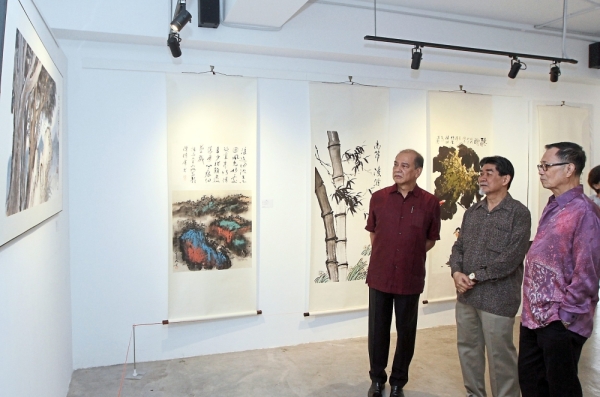 Enthralling artworks : (From left) Chan, Cheng and Fu looking at paintings at the joint art exhibition ‘Trilogy’ at Clarity Art Centre in Cheras.