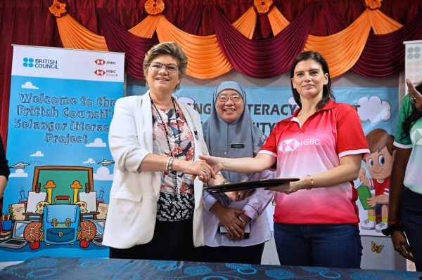 Deverall (left) and Latini shaking hands after the MoU signing ceremony while Dr Habibah (centre) looks on.