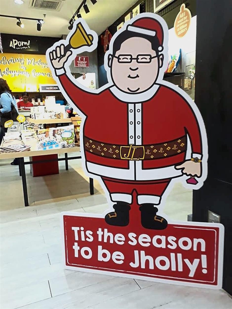 Naughty Santa: The life-sized ‘mascot’ greeting customers at the entrance to Apom Store in Bangsar, and the Christmas card (below).