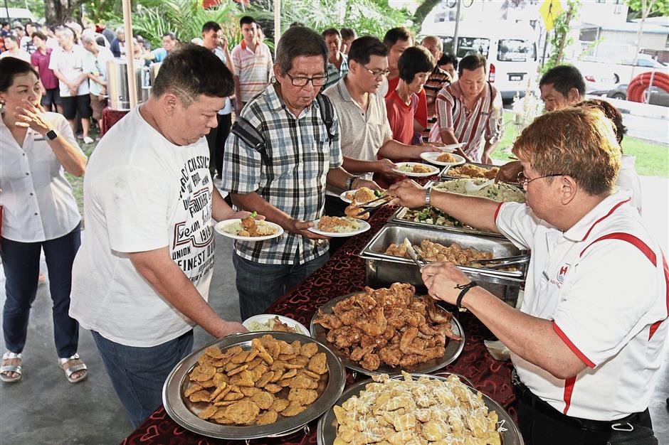 Guests queuing up to savour the buffet spread at the Taman Lalulintas MPKK Chinese New Year celebration.