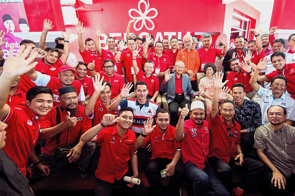 All together in unity: Dr Mahathir and Tun Dr Siti Hasmah posing with Bersatu members to commemorate the launch of the Terengganu Bersatu headquarters in Ladang Tok Pelam in Kuala Terengganu. — Bernama