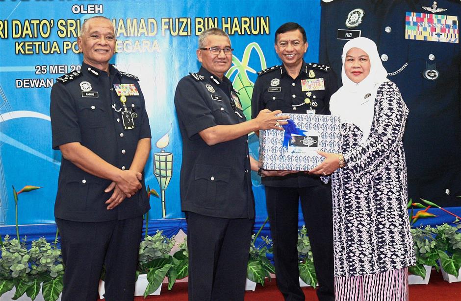Closer ties: Mohamad Fuzi receiving cookies from chairman of Perkep (Police Family Association) Puan Sri Shahriza Saad Mansor during the handing over of Raya goodies in Bukit Aman, Kuala Lumpur. Looking on are Bukit Aman Internal Security and Public Order Department director Comm Datuk Seri Zulkifli Abdullah (second from right) and Deputy Inspector-General of Police Tan Sri Noor Rashid Ibrahim.