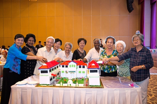 Convent Bukit Mertajam old girls cutting the 85th anniversary cake which is shaped like their school building.