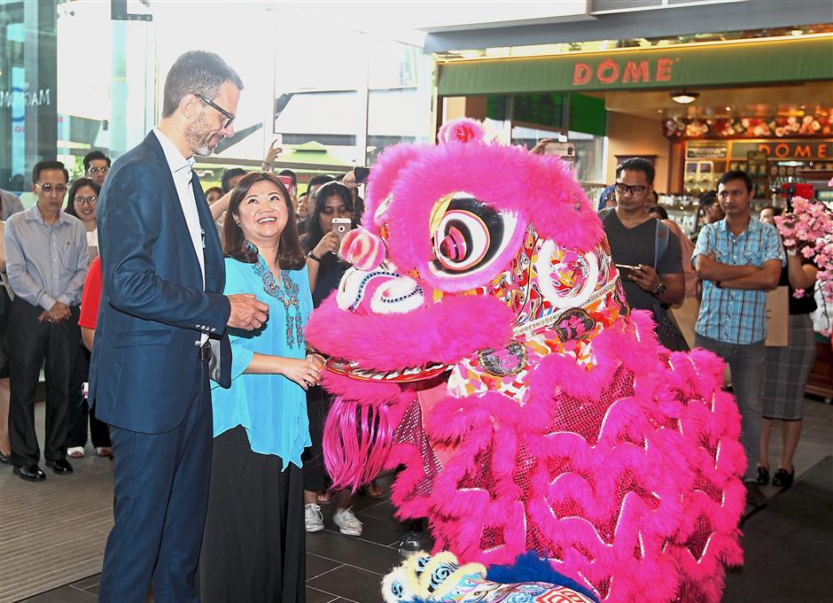 Malmberg (left) and Lim being greeted by a lion during the lion dance performance.