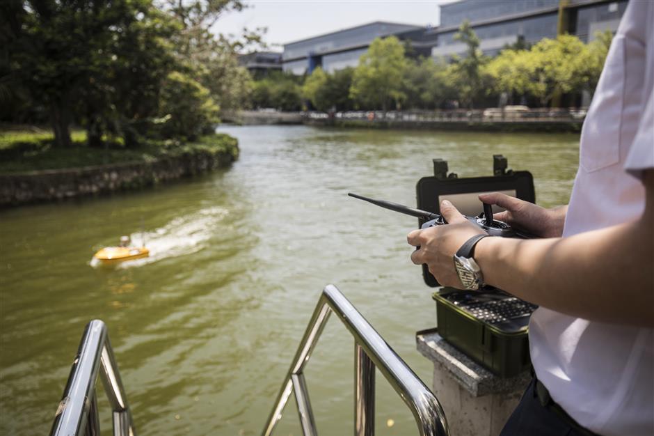 A technician manoeuvres an Oceanalpha Co. unmanned surface vessel in a pond using a remote control outside the company's offices in Zhuhai, China, on Thursday, May 18, 2018. Oceanalpha, one of a handful of companies around the globe specializing in ocean-going drones that operate on the surface, has fired the interest of some of China's biggest venture capitalists. Photographer: Qilai Shen/Bloomberg