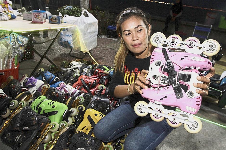 Operator Surayahani Mohd Shahab, 39, showing a pair of roller skates at her spot along Karpal Singh Drive.