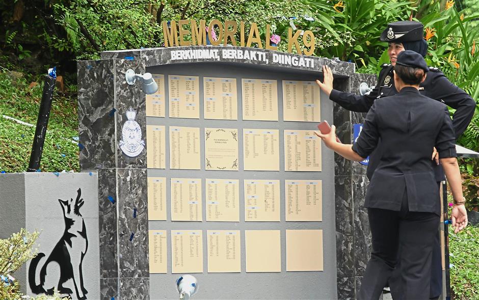 Unsung heroes: Police personnel taking a closer look at the K-9 memorial at the Police Training Centre in Jalan Semarak, Kuala Lumpur.