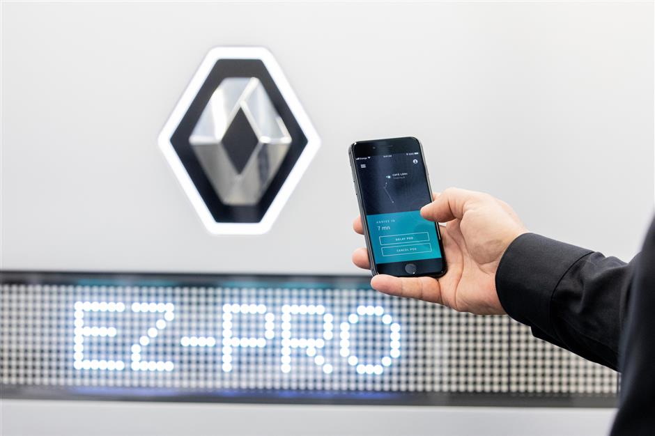 An employee demonstrates a customer collection smartphone app as the Renault EZ-Pro autonomous prototype concept commercial vehicle is unveiled at the Renault SA automobile research center in the Guyancourt suburb of Paris, France, on Wednesday, Sept. 12, 2018. With side flaps that open up like a food truck, Renault said the design was inspired by the look of a lunch box. Photographer: Christophe Morin/Bloomberg