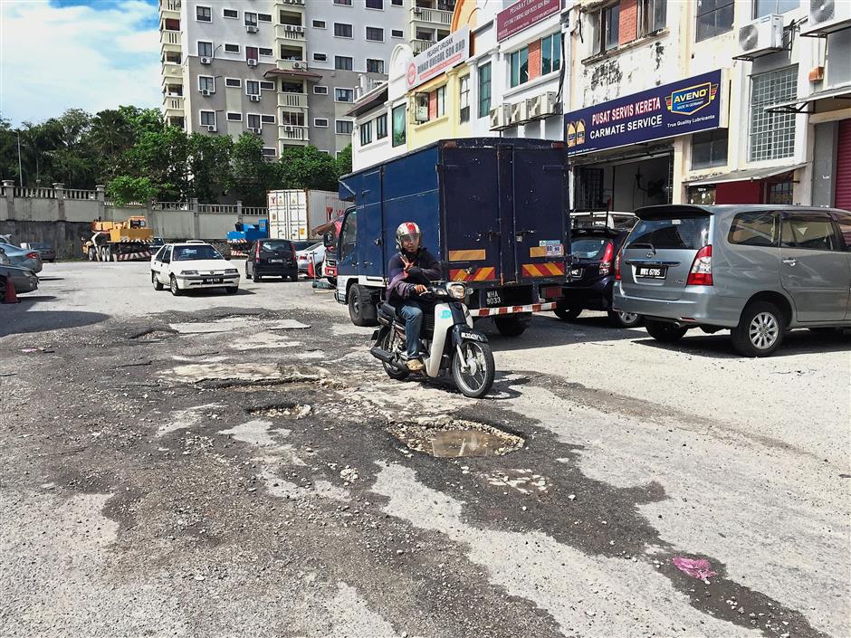 The potholes along Jalan TK 5/42 have gotten worse over the years and have not been paved though complaints were made.