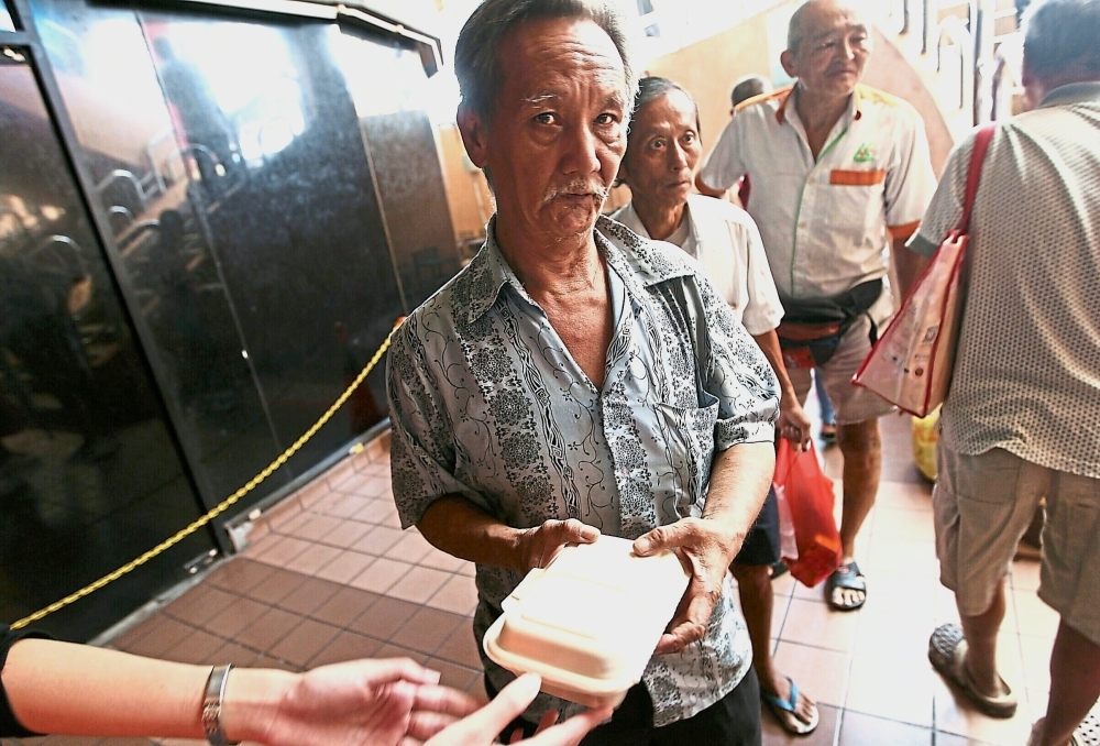 Senior citizens lining up for their meal packets. Some claim that there are up to 200 homeless people in the Pudu area.