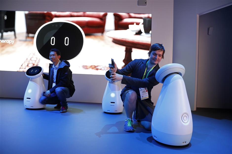 Jason Stettner, right, takes a picture with a Bot Care robot in the Samsung booth at CES International, Tuesday, Jan. 8, 2019, in Las Vegas. (AP Photo/John Locher)