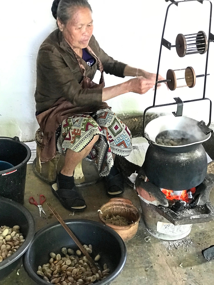 A woman extracting the silk from the cocoon that will be processed for weaving.