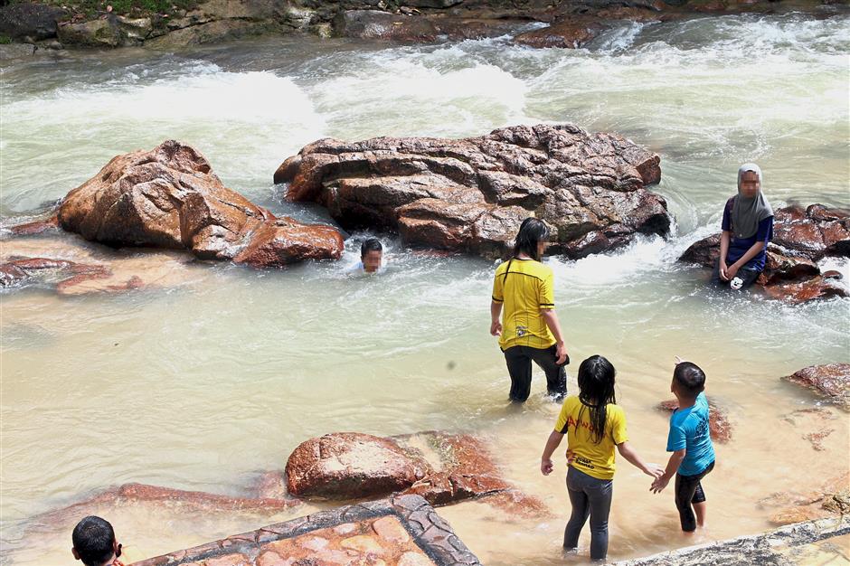 A file image of children playing in a stream. Fire and Rescue Department officials say people going to such areas should always check on weather conditions first and always keep an eye on youngsters.