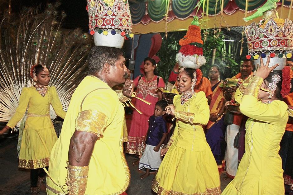 Karakattam dancers balancing pots on their heads in their performance.
