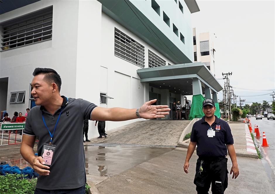 Clear the area, please: Officers standing guard in front of Chiang Rai Hospital, where the boys and their coach will get treatment. — Reuters