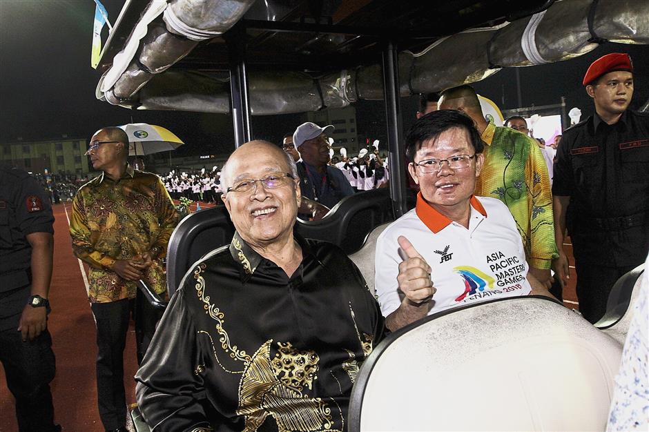 ^ Abdul Rahman and Chow taking a buggy ride around the stadium.