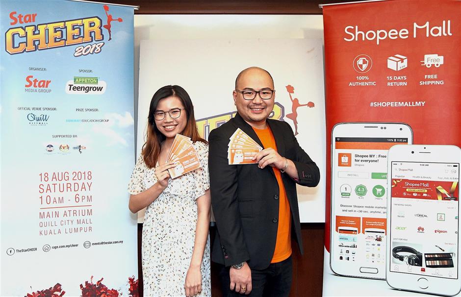Liew and Star Media Group business intelligence executive Amanda Lessler with some of the RM8 Shopee vouchers that the online retailer is sponsoring for Cheer 2018.