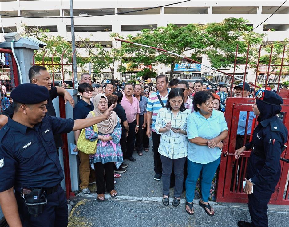 Voters were already gathered at the gate outside SJK(C) Lee Rubber in Wangsa Maju before the start of voting at 8am. — Ong Soon Hin/The Star