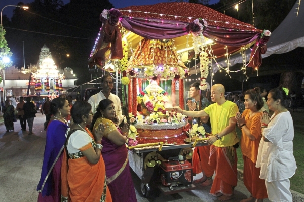 Lim (in yellow) and Wong (second right, in orange) joining other devotees in offering prayers to Lord Ganesha at the Bhajan cart as the chariot prepares to leave the Arulmigu Balathandayuthapani Hilltop Temple in Waterfall Road. (Left pic, from left) Luoto and Rautavaara from Finland enjoying the Chitraparuvam Festival.