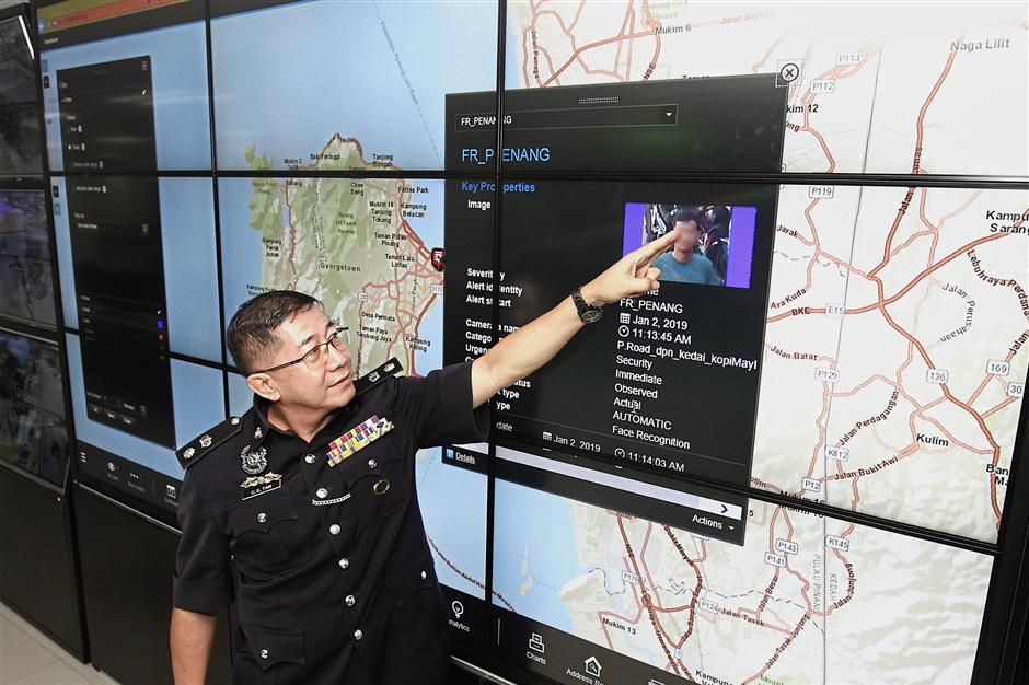 Closer look: A police officer showing the facial recognition system at MBPP’s CCTV Control Room in Komtar, Penang.