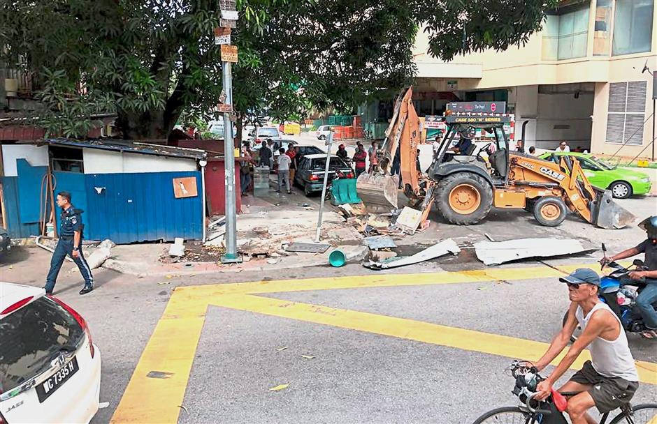The city council used heavy machinery to tear down some of the stalls during the operation.