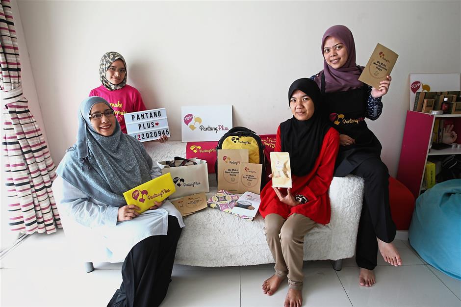 Pantang Plus founder and chief executive officer Zamzana Mohd Arifin with her staff and some of the merchandise they offer, at the company’s HQ. - S.S.KANESAN/The Star
