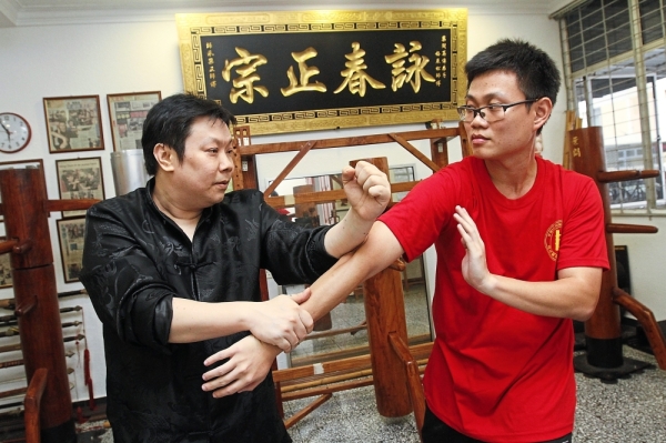 (From left) Boey teaching student Jack Tang, 31, at the centre.