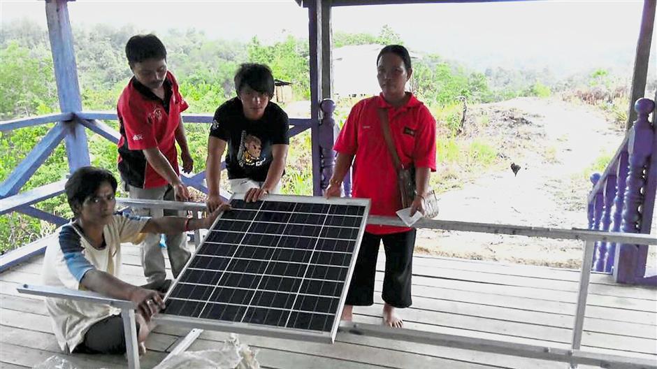 Productive project: A solar panel ready fo use in Sabah, thanks to Swepa’s Barefoot solar project. (Inset) Tambakau’s humble background drove her to help others.