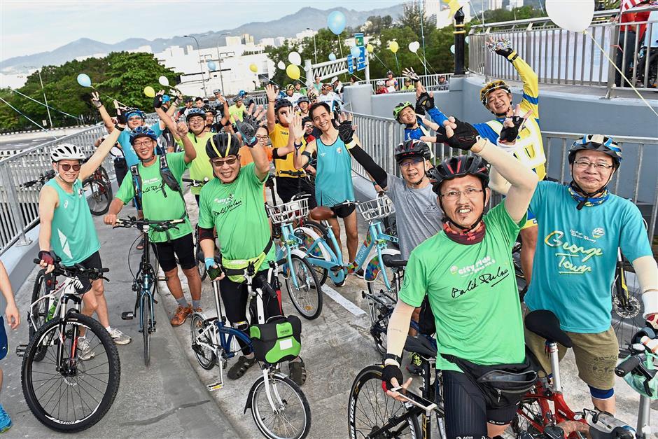 Cyclists posing for the camera on the bridge.