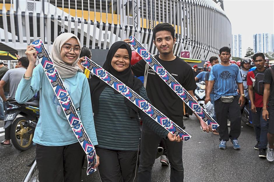 Lucky trio: Harimau Malaya supporters showing off their tickets at the stadium. — Bernama