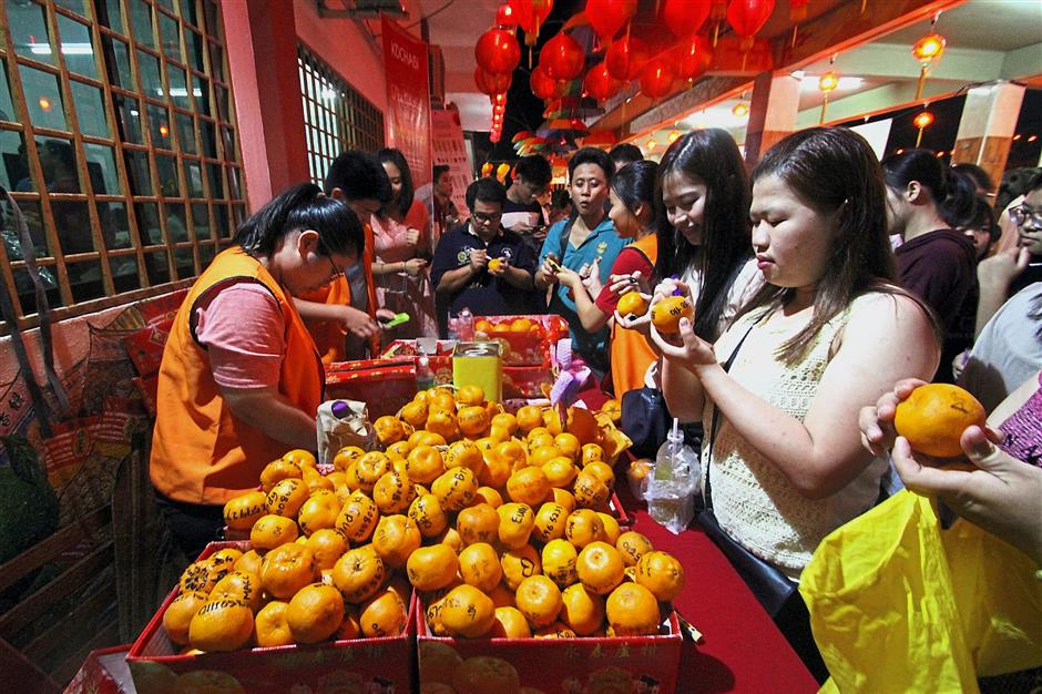Many visitors were seen writing their phone numbers on mandarin oranges for the festival.