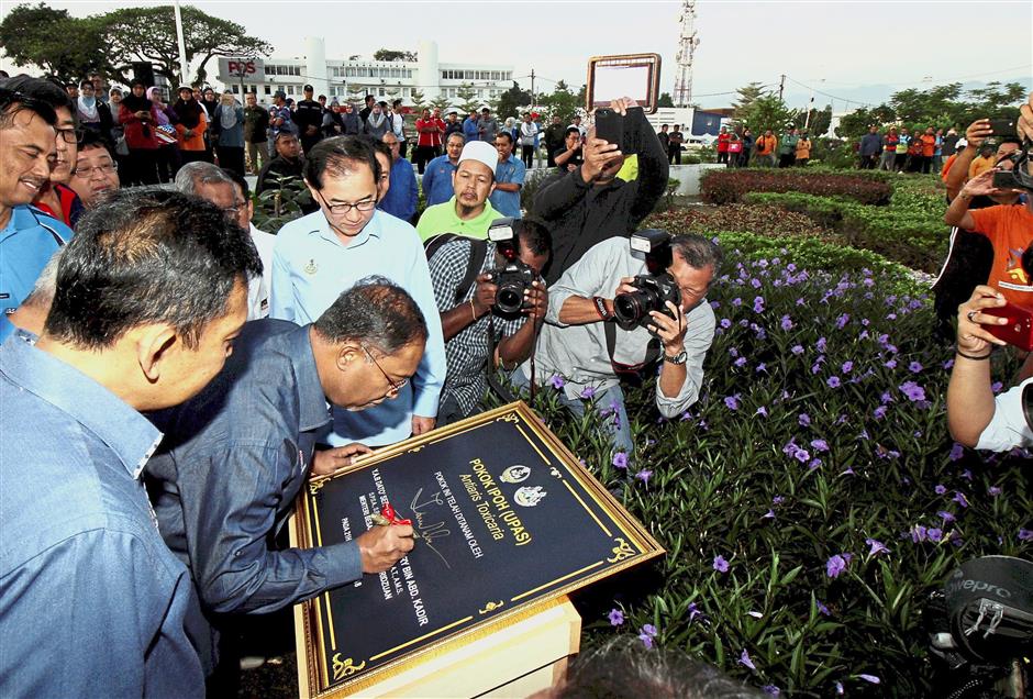 Zambry signing the plaque after planting the Ipoh Tree infront of the Ipoh Railway Station.