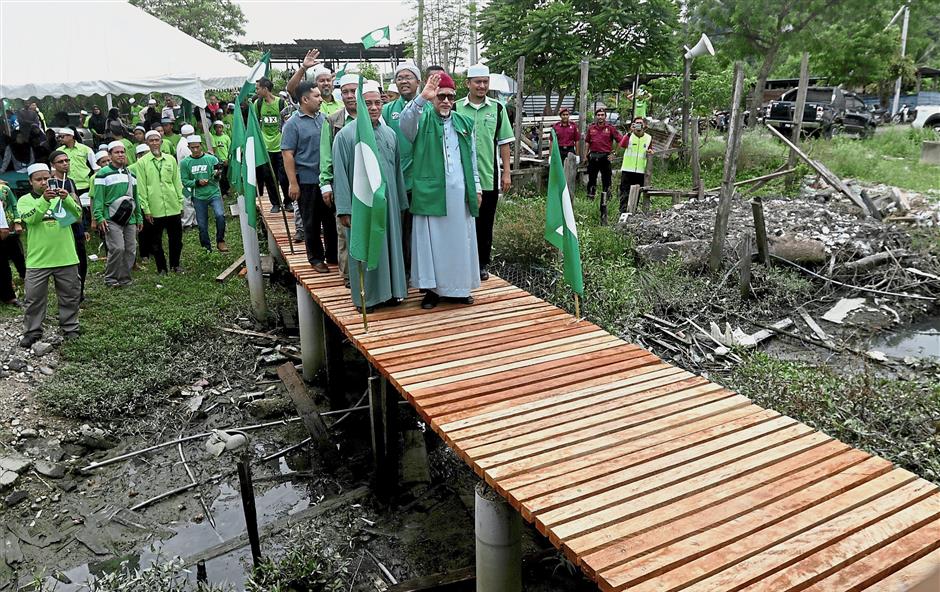 Easier route: Abdul Hadi waving to supporters after opening the walkway in Kampung Juru, Bukit Mertajam. Inset: Afnan.