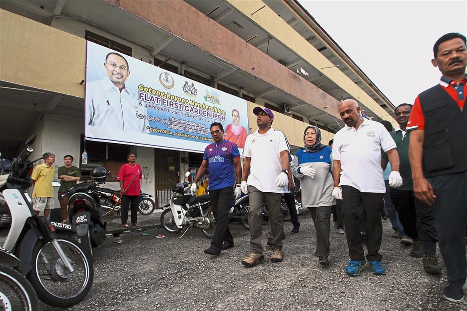 Zambry (wearing cap) ?with Rusnah? (in tudung) visited the flats with government agencies and NGOs to clean up the area and learn first-hand about issues affecting residents.