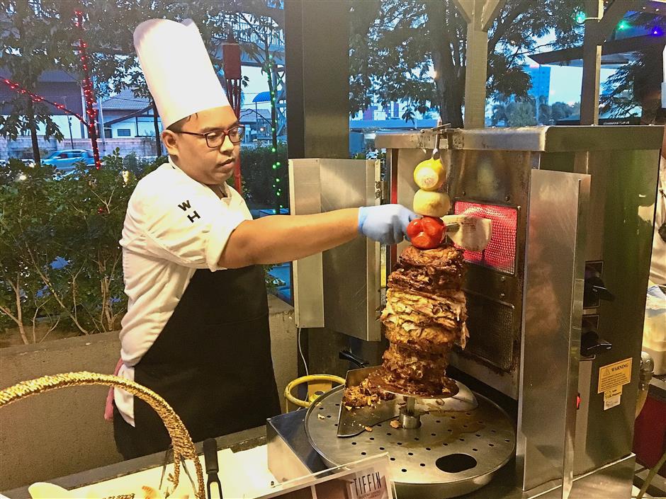 A Weil Hotel chef preparing the shawarma for the Ramadan buffet promotion at an action stall at the Tiffin Restaurant.