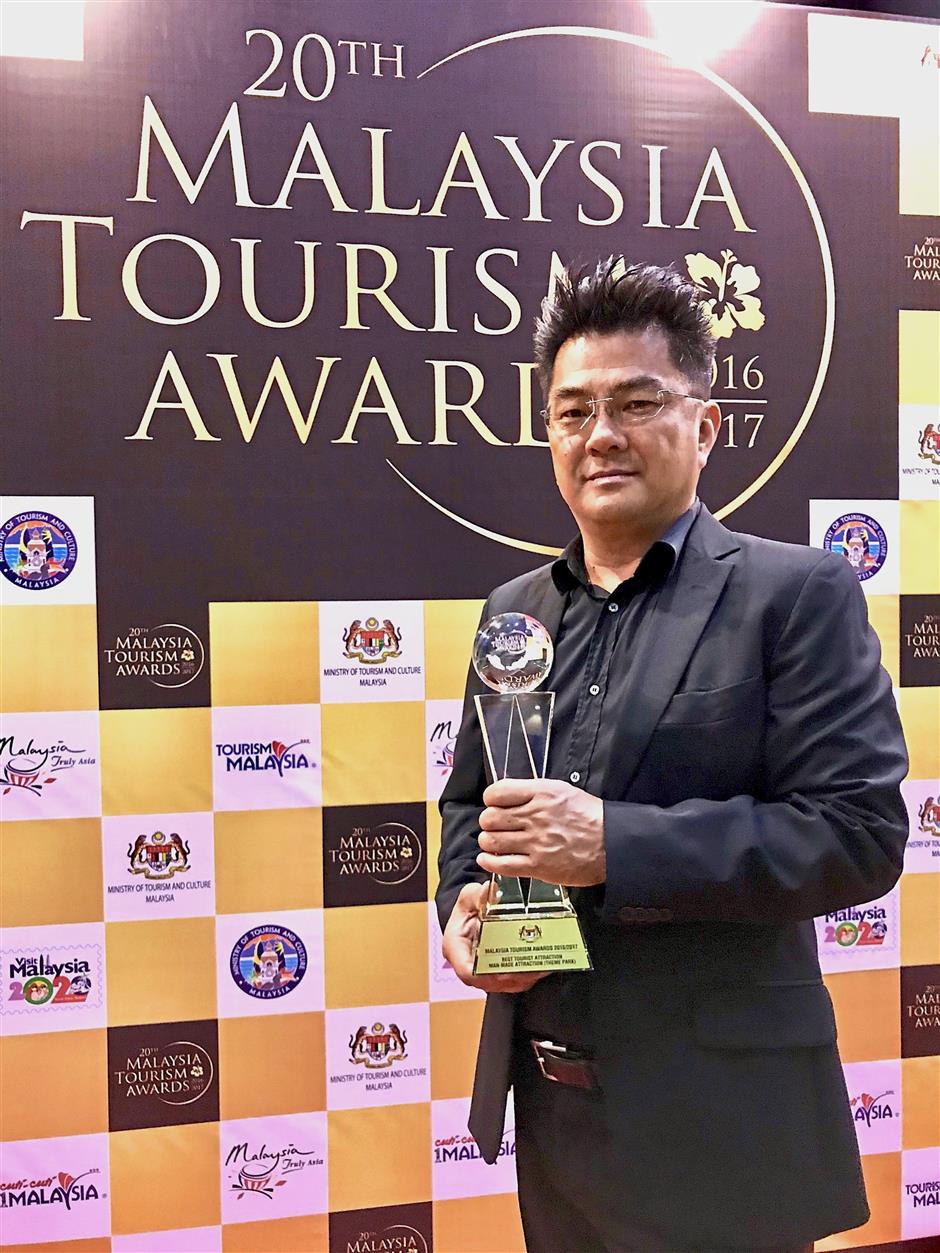Sim posing with the trophy for Best Tourist Attractions (Man-made Attraction - Theme Park) won in the Malaysia Tourism Awards 2016/2017.