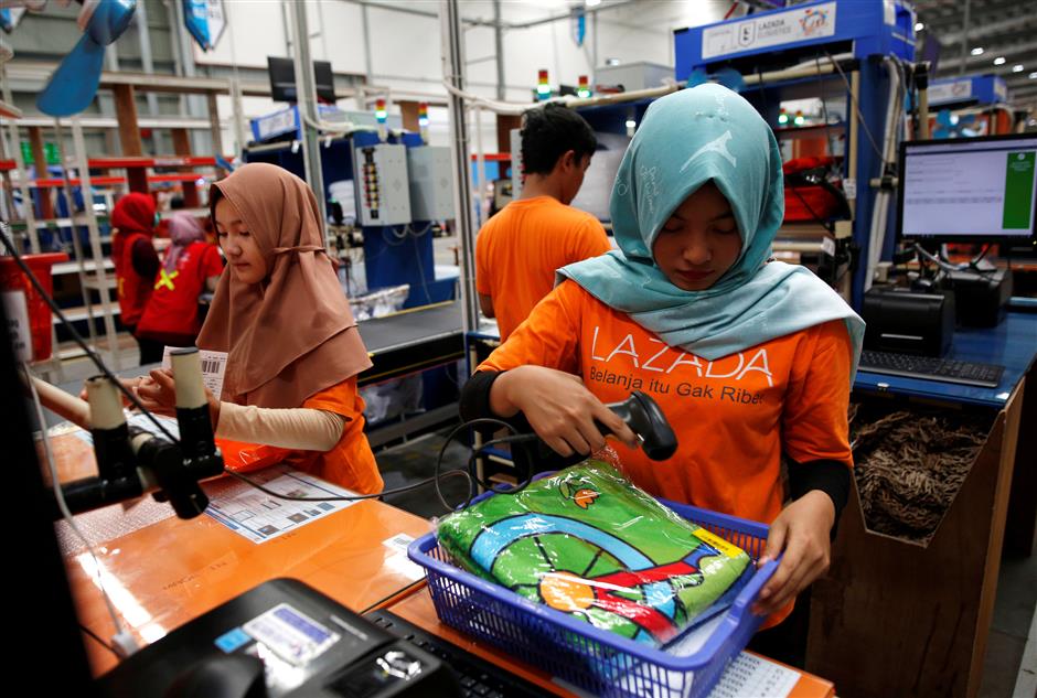 Workers pacakge items for delivery at online retailer Lazada's warehouse in Depok, south of Jakarta, Indonesia March 26, 2018. Picture taken March 26, 2018. REUTERS/Darren Whiteside