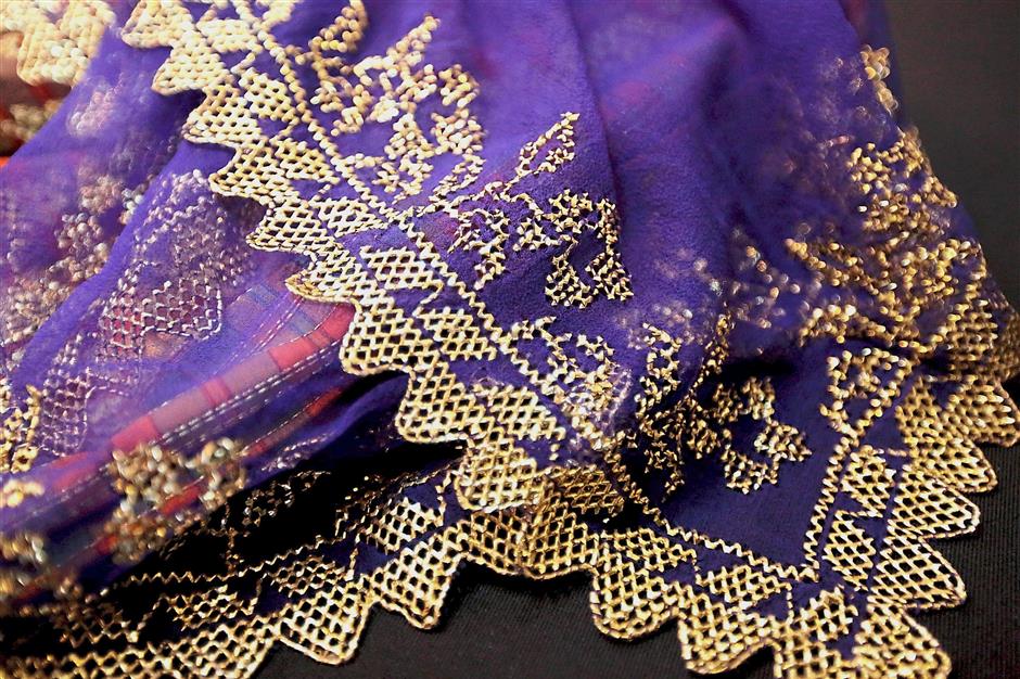 Another intricate piece of keringkam scarf golden embroidery handstitched on a purple background.