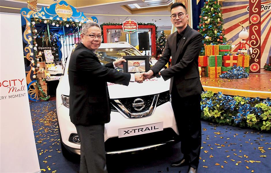 Wong (left) receiving the Nissan X-Trail 2.5l CVT from Edaran Tan Chong Motor marketing deputy general manager Phang Rick Kee.