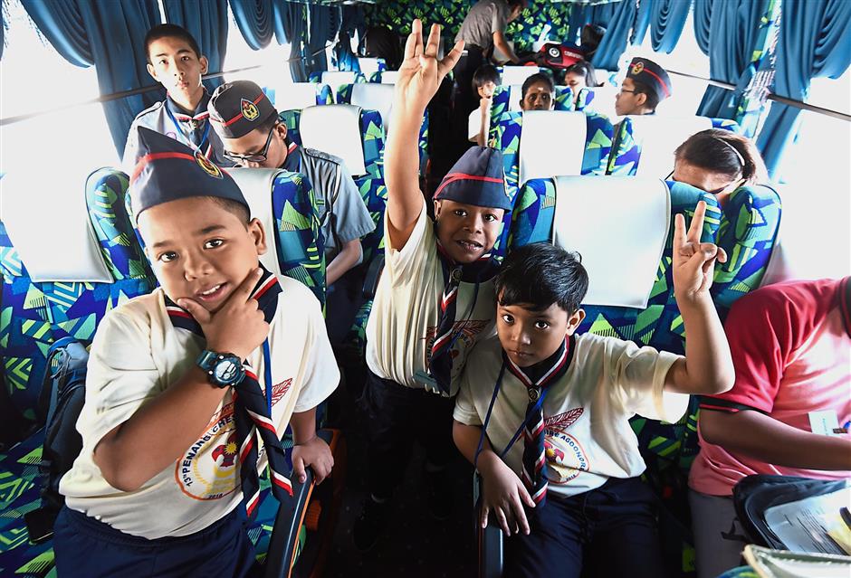 Three SK Pendidikan Khas Jalan Hutton special Scouts (from left, in front) Mohd Fakhrullah Rashidi, 11, Mohd Irman Firdaus Ismail, 10, and Mohd Izzul Adli Nordin, 10, in high spirits as they leave for the agoonoree.