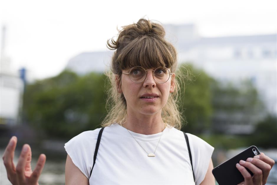 In this Tuesday, May 21, 2019 photo, Annekathrin Fiesinger talks about her motivation to use a food sharing app to reduce food waste during an interview with the Associated Press in Berlin. In Germany, growing numbers of people use modern technology such as phone apps to help reduce food waste. In an effort to cut down on climate-wrecking carbon dioxide emissions created by food waste, they build online communities to share food before throwing it away. (AP Photo/Markus Schreiber)