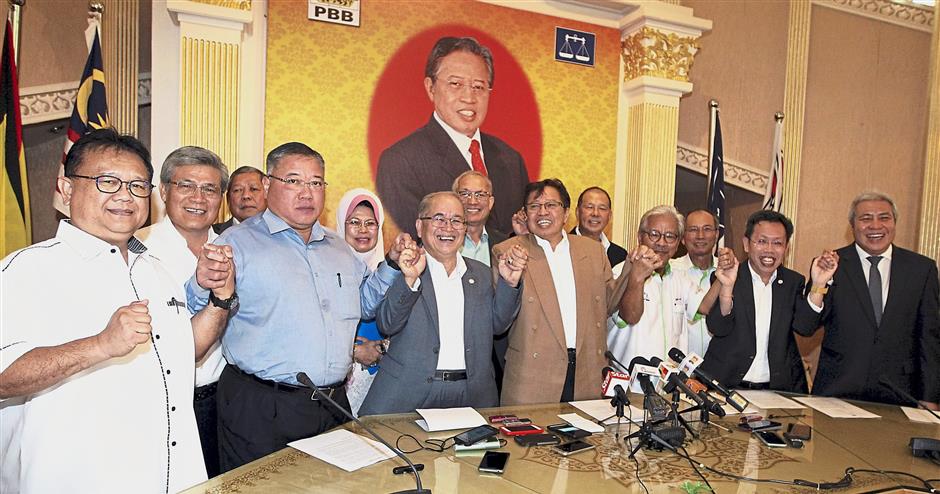 Group effort: Abang Johari (light brown jacket) and party leaders of PBB, PRS, PDP and SUPP joining hands in a show of unity after a meeting at the PBB headquarters in Kuching.