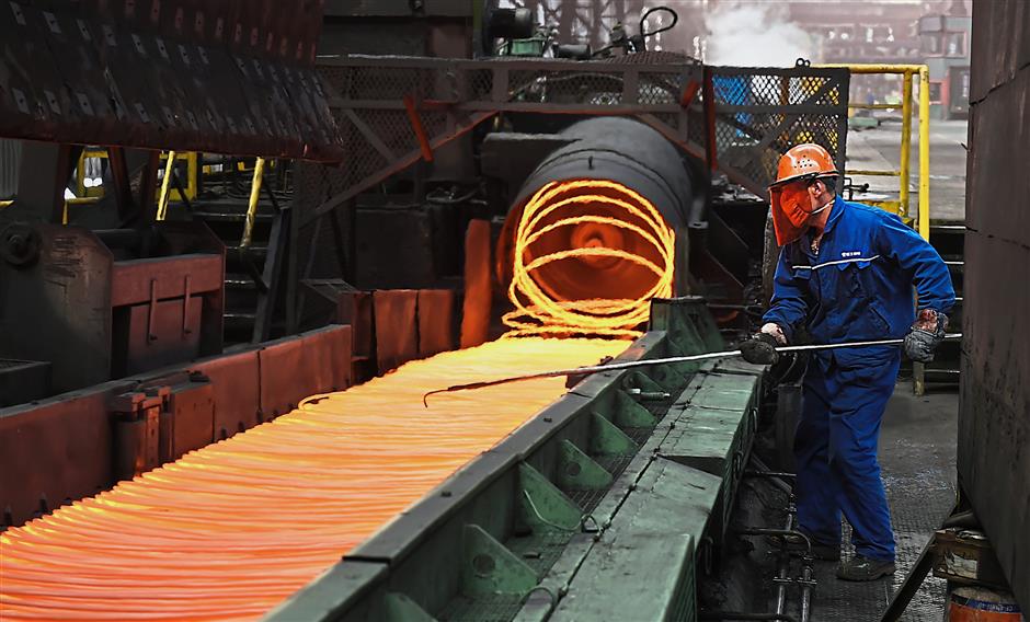 Firm protest: A worker manipulating coils of steel at Xiwang Special Steel in Zouping county in eastern China’s Shandong province. China says it ‘firmly opposes’ Trump’s tariff increase for imported steel and aluminium but gave no indication whether Beijing might impose its own measures in response. — AP