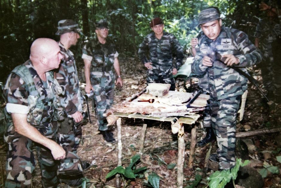 Keeping a close watch: Toh (in red beret) looking on ?during a jungle operation. Inset: Toh in his official uniform.