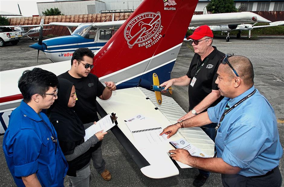 (From left) Tan , Hasnor Farah and Muhammad Fakhrul play the role of flight test engineers, as they brief Dr Zairil (right) and Walther before their flight testing. — Photos by S.S. Kanesan/the Star