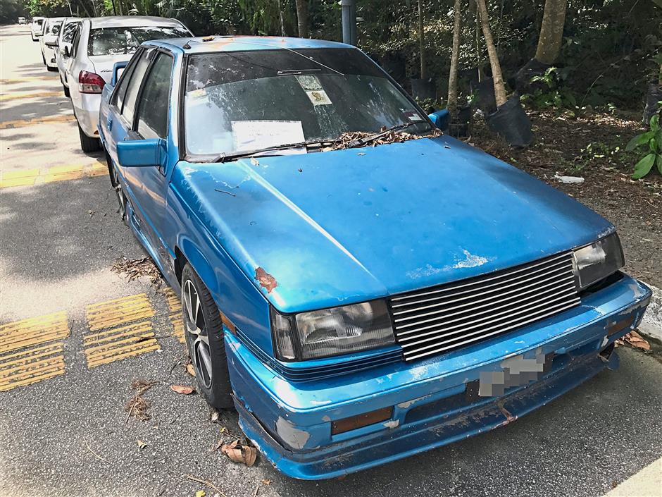 A note on the windscreen asking the car owner to contact an individual if he wishes to sell this car dumped near the food court at Tingkat Kenari in Sungai Ara.